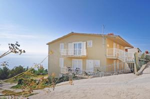 a house on a hill with the ocean in the background at Apartments Sunspot 1 in Lokva Rogoznica