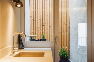 a bathroom with a sink and a window with potted plants at El Call LEstudi en la judería de Besalú in Besalú