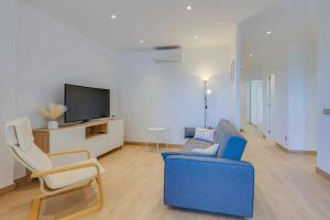 a living room with a blue couch and a tv at Apartamento Condal in Blanes
