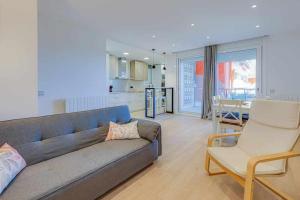 a living room with a blue couch and a kitchen at Apartamento Condal in Blanes