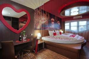 a bedroom with a bed with a heart on the wall at Hotel Corvin in Gyula