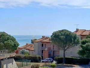 una casa con un albero e l'oceano sullo sfondo di T2 vue Mer - St Pierre la Mer 2PLM67 a Saint Pierre La Mer