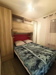 uma cama num pequeno quarto com uma grande cama sidx sidx em T2 vue Mer - St Pierre la Mer 2PLM67 em Saint Pierre La Mer