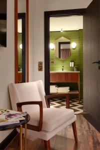 a living room with a white chair and a mirror at Brama in Bromley