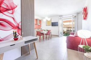 Una sala de estar con un sofá rojo y un comedor. en Skyfive Fire Apartment, en Alghero