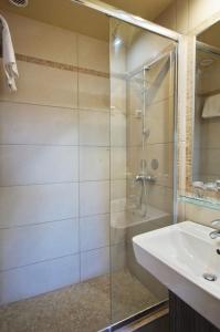 La salle de bains est pourvue d'une douche et d'un lavabo. dans l'établissement Hotel Corvin, à Gyula