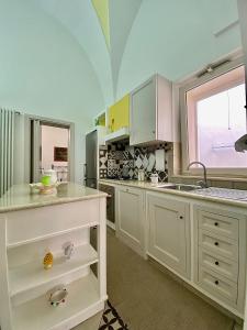 a kitchen with white cabinets and a sink and a window at La casa di Francesca in Casarano