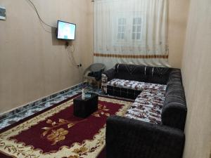 a living room with a couch and a tv at Dakrour flat in ‘Izbat Ţanāţī