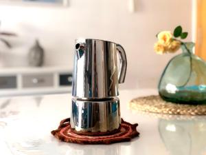 Eine silberne Kaffeekanne steht auf einem Tisch mit einer Vase. in der Unterkunft Duplex RIO EBRO in Deltebre + 16 Fotos