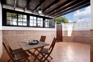 a patio with a wooden table and chairs at Apartamento White Sun in Playa Honda