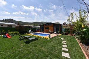 un patio trasero con una casa pequeña con piscina en Arkaya TinyHouse en Fethiye