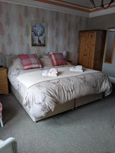 a bedroom with a large bed with red pillows at Gowanbrae Bed and Breakfast in Dufftown