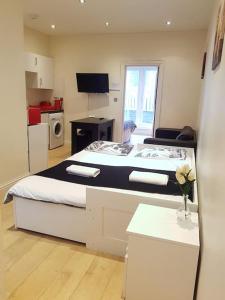 een kleine kamer met een bed en een keuken bij Modern Apartment in Great Location in London in Londen