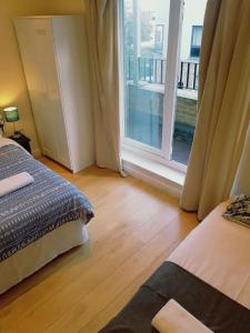 een slaapkamer met een bed en een raam met een balkon bij Modern Apartment in Great Location in London in Londen