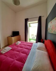 um quarto com uma grande cama rosa e uma janela em La Casa del Borgo em Lecce