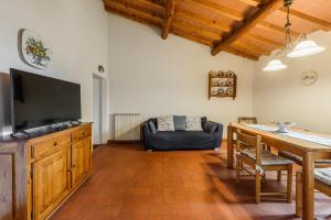 a living room with a television and a table with a couch at Tenuta Poggio ai Mandorli in Greve in Chianti
