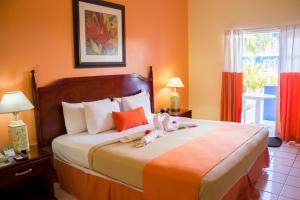 a bedroom with a bed with two stuffed animals on it at Bay Gardens Inn in Gros Islet