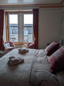 a bedroom with a large bed with two towels on it at Gowanbrae Bed and Breakfast in Dufftown