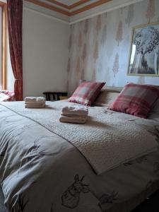a bedroom with a large bed with towels on it at Gowanbrae Bed and Breakfast in Dufftown