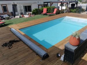 a swimming pool with a hose on a wooden deck at Gite de PHAM in Belberaud