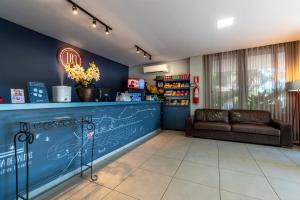 a waiting room with a couch and a counter at 103 Hotel & Flats in Palmas