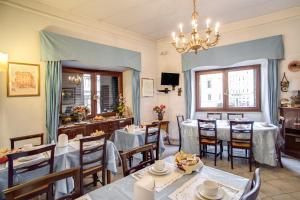 un restaurant avec des tables et des chaises et un lustre dans l'établissement Hotel Primavera, à Rome