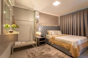 um pequeno quarto com uma cama e um espelho em 103 Hotel & Flats em Palmas