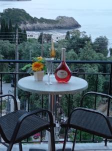 a table with a bottle of wine and a glass at LITHERI-Studios&Apartment in Paleokastritsa