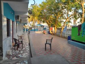 a group of chairs sitting on a brick sidewalk at Arputha Lodge in Nāgappattinam