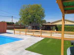 a wooden fence next to a swimming pool at Piscina de sal Barbacoa Wifi, Parking Gratis, 3 min PGA Casa El Roble in Girona