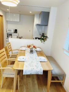 a dining room table with chairs and a kitchen at 成田羽田空港直行 skytree 上野 asakusa 銀座直行 駅から徒歩8分新築戸建 駐車場付いてない in Tokyo