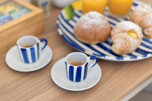 dos tazas de café y platos de repostería en una mesa en Tenuta Di Leva, en Piano di Sorrento