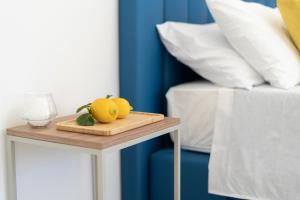 bandeja de madera con naranjas en una mesa junto a la cama en Tenuta Di Leva, en Piano di Sorrento
