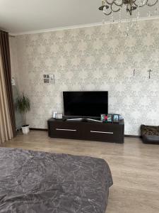 a bedroom with a bed and a flat screen tv at ВІП квартира в новобудові в центрі міста in Rivne