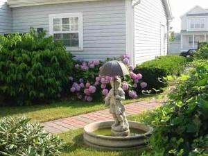 a statue of a woman holding an umbrella in a yard at AMAZING!!!! Luxury 5BR, Steps to beach and Fun! Fully Renovated Beach house! in Atlantic City