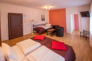 Un dormitorio con una cama grande con almohadas rojas. en Berghotel Waidmannsheil, en Battenberg