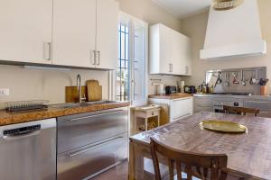 cocina con armarios blancos y mesa de madera en Villa sui Colli Bolognesi by Wonderful Italy, en Bolonia