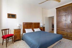 1 dormitorio con 1 cama azul y 1 silla roja en Villa sui Colli Bolognesi by Wonderful Italy, en Bolonia