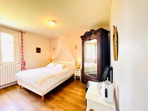 a bedroom with a bed and a mirror in it at Manoir de la Marjolaine in Cabourg