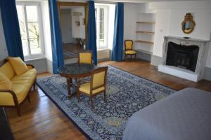 een woonkamer met een tafel en stoelen en een open haard bij Les Distinguées - L Ayral in Gaillac-dʼAveyron