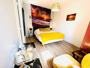 a bedroom with a bed with a yellow blanket at Manoir de la Marjolaine in Cabourg