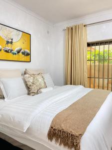 1 dormitorio con 1 cama blanca grande y ventana en Ranzi Court Guest House en Palapye