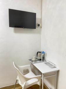 a white table and a white chair in a room at Ranzi Court Guest House in Palatswe