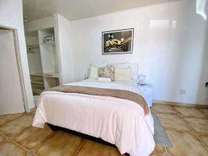 sypialnia z dużym łóżkiem w białym pokoju w obiekcie Ranzi Court Guest House w mieście Palapye