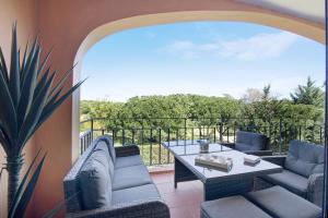 Un patio con dos sillas y una mesa en un balcón. en Apartamento T2 Vilasol Morgadinho, en Vilamoura