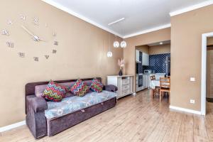 uma sala de estar com um sofá e uma cozinha em Абрикосовое парфе em Astana