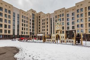 a large building with a clock tower in the snow at Абрикосовое парфе in Astana