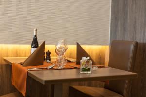 a table with a bottle of wine and a wine glass at Hotel Les Mouettes in Wenduine