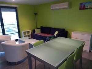 ein Wohnzimmer mit einem Sofa, einem Tisch und Stühlen in der Unterkunft Lacs de l'eau d'heure B25 in Erpion