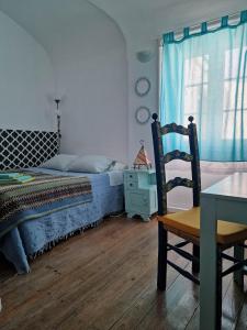 a bedroom with a bed and a chair and a table at The Aqueduct Guesthouse in Évora